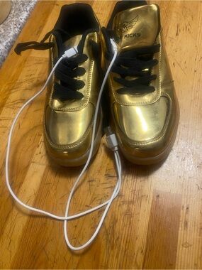 Gold Metallic Women's Sneakers with Black Laces light up with wires to charge.